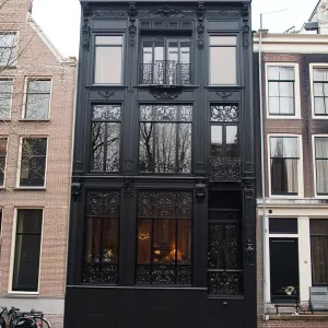 Venetian-styled Canal House With Ornate Dark Ironwork and Deep Emerald Interiors